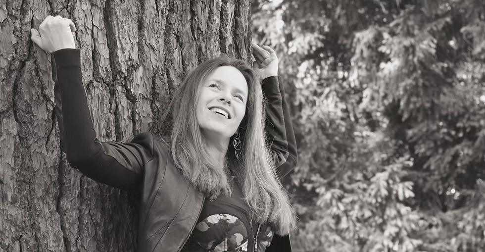 Natacha Kozlowska, souriante, adossée à un arbre